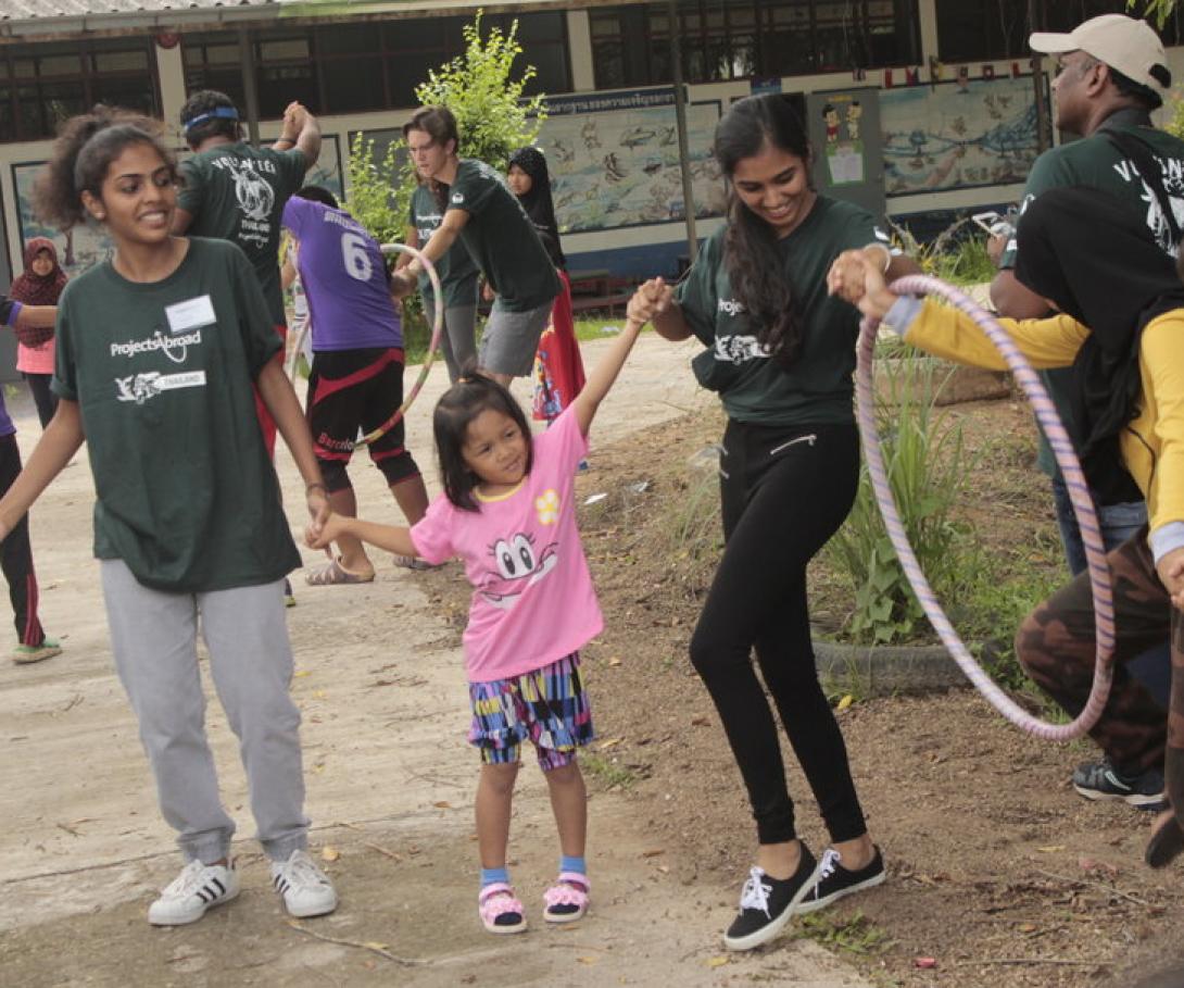 Thai children play outdoors with a group of students from the Canadian International School in India. A group of volunteers from the Canadian International School in India play a game with kids in Thailand.